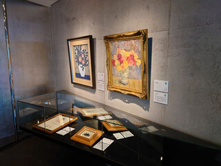 壁面と展示ケースに、版画や油彩画が展示されている様子