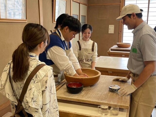 お客様に蕎麦の打ち方を教える隊員