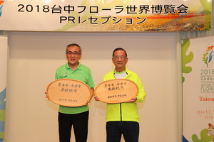 奥塚市長が、中津市からの記念品として木製プレートを贈りました。