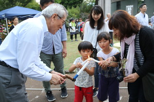 来場者と火を分け合う奥塚市長