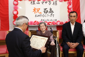 お祝いの言葉を伝える奥塚市長