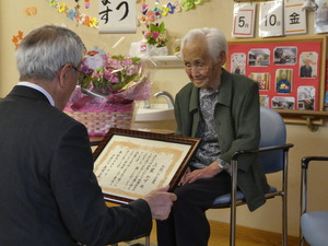 お祝いの言葉を伝える奥塚市長