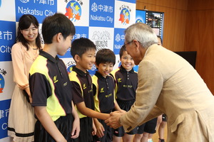 握手で送り出す奥塚市長