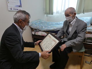 表彰状を読み上げる奥塚市長（写真左）