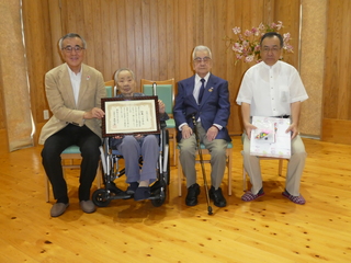 加耒さん夫婦らと写真を撮る奥塚市長（左）