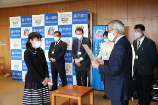 任命書交付の様子（写真右手前が奥塚市長、左手前が本田さん）