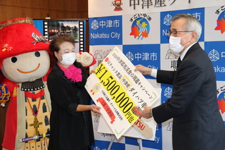 当選者に賞品パネルを手渡す奥塚市長（写真右）
