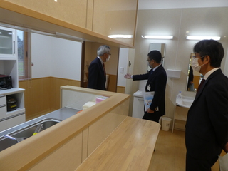 調理室を見学する奥塚市長（写真左）