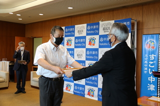 表彰状を手渡す奥塚市長（写真右）