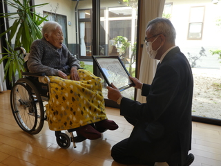 お祝い状を渡す奥塚市長