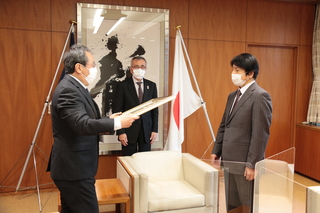 伝達の様子（写真中央が奥塚市長、右が西畑さん）