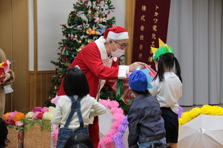 清浄園で子どもたちにプレゼントを手渡す奥塚市長