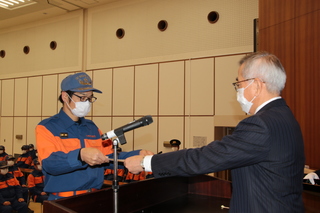 表彰状を手渡す奥塚市長（写真右）