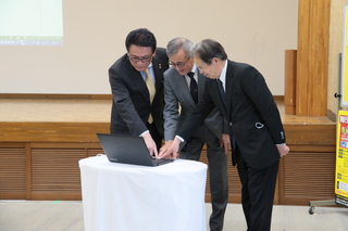 抽選ボタンを押す奥塚市長（写真中央）