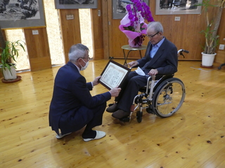 お祝い状を渡す奥塚市長（写真左）