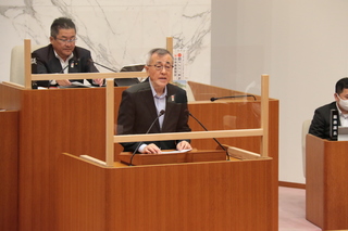 提出議案の説明をする奥塚市長（写真右））