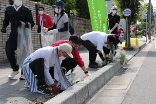 ごみを拾ったり道路の雑草を抜いたりする奥塚市長ら