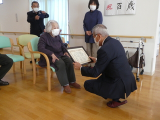 恵良さんに表彰状を読み上げる奥塚市長