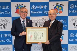 表彰状を一緒に持つ新貝氏と奥塚市長