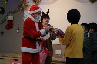 聖ヨゼフ寮で子どもたちにプレゼントを渡す奥塚市長