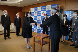 交付する様子（奥塚市長は写真左）