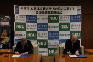 署名をする奥塚市長（写真左）と日本文理大学学長（写真右）